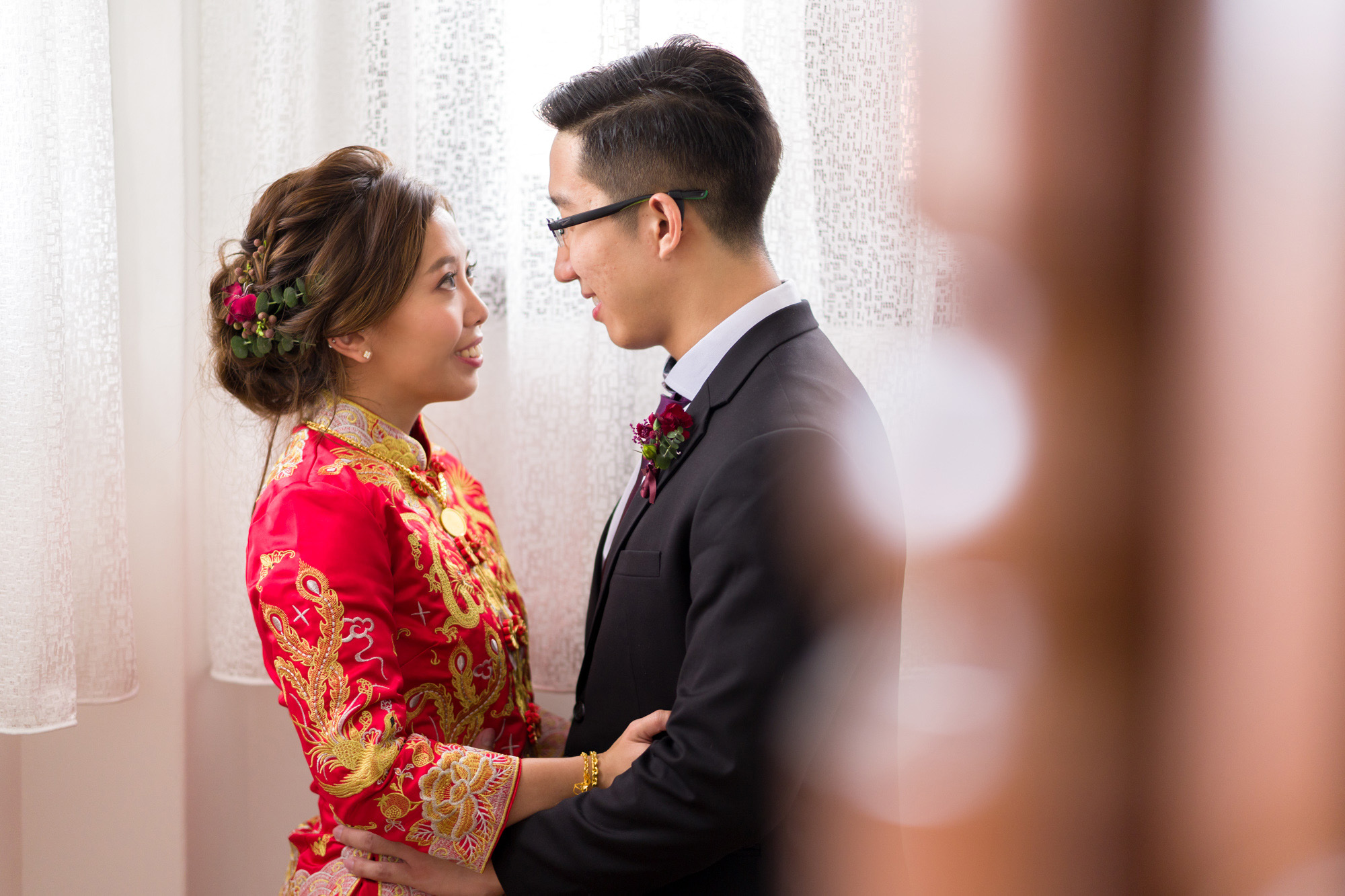 Bride smiling beside her gown before the bridal makeup trial
